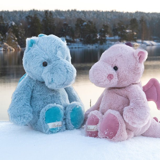 Pink dragon plush and blue dragon plush sitting together