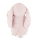 Rear view of a pink plush bunny with long ears and a small tail.
