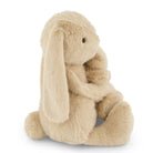 Side view of a plush, tan bunny rabbit toy sitting.